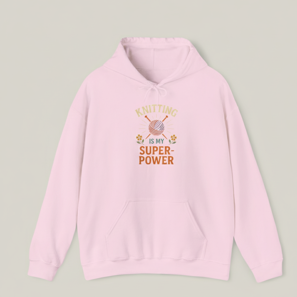 Pink hoodie with 'Knitting is my superpower' text and yarn design on a light gray background