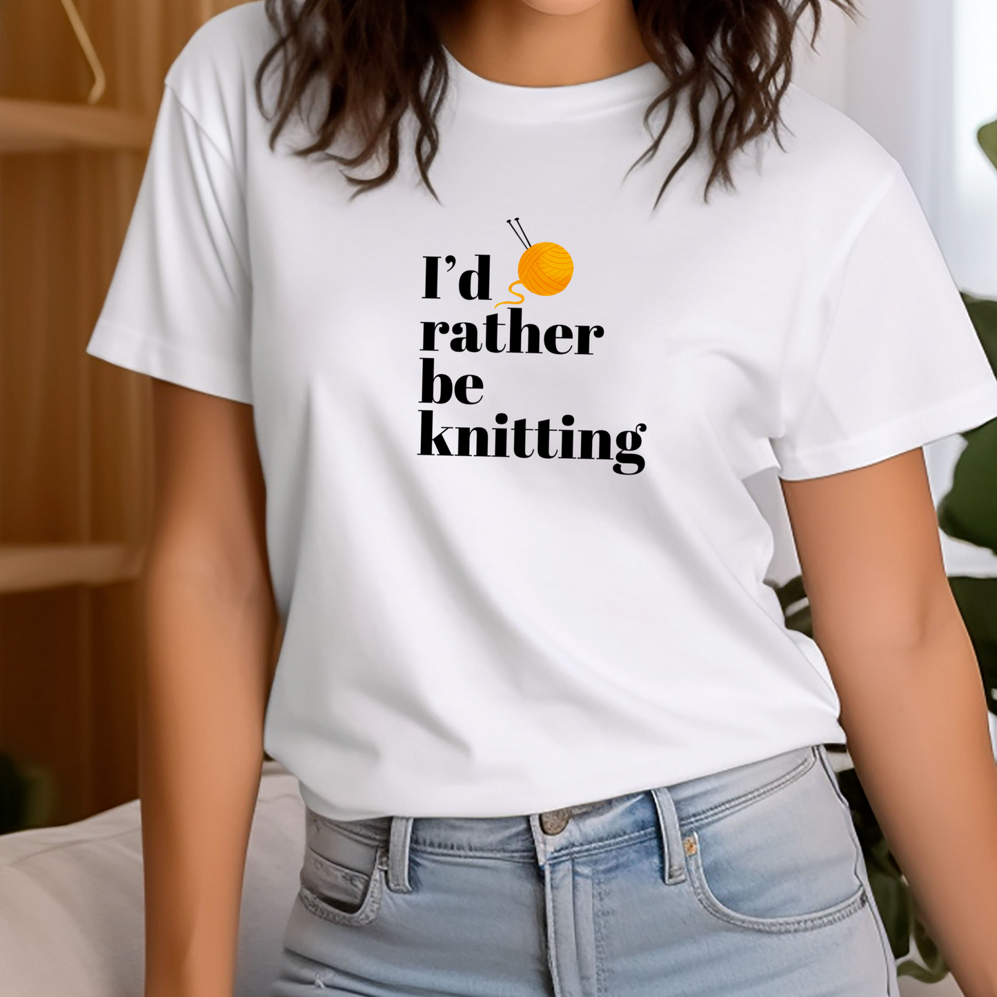 Person wearing a white t-shirt with 'I'd rather be knitting' text and yarn ball graphic.