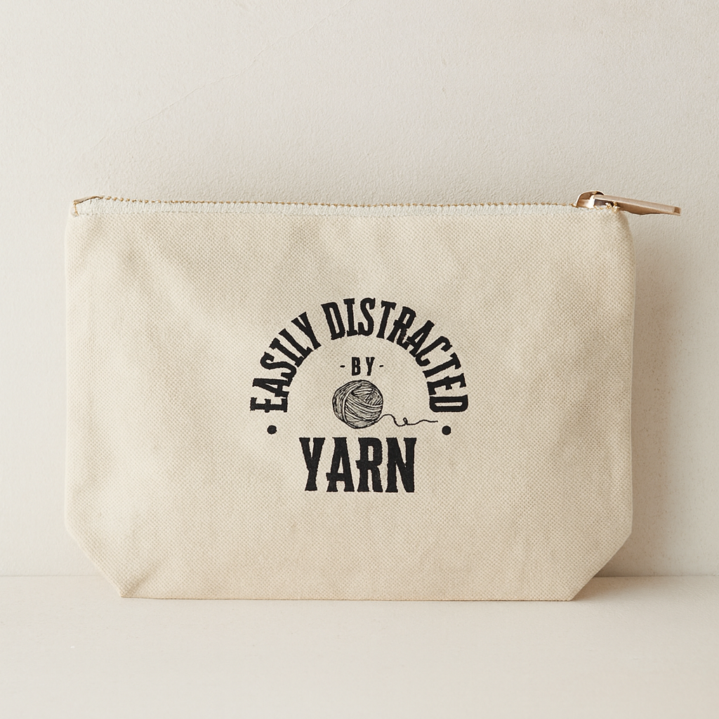 A natural color notions bag with 'Easily Distracted by Yarn' text on the bag.  The bag is against a white background