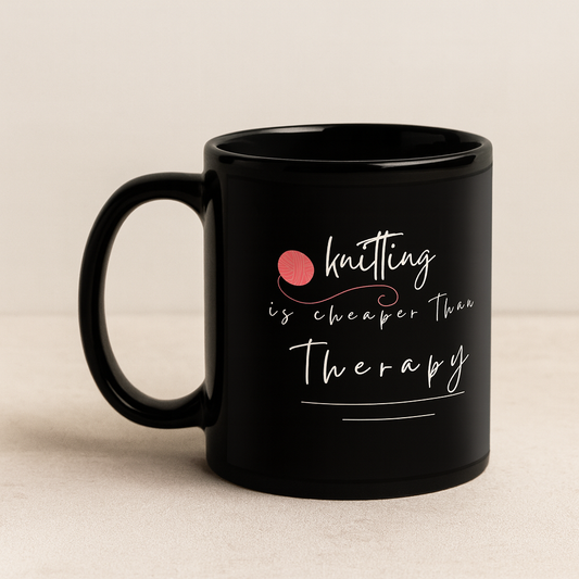 Black mug with 'Knitting is cheaper than therapy' text on a beige background