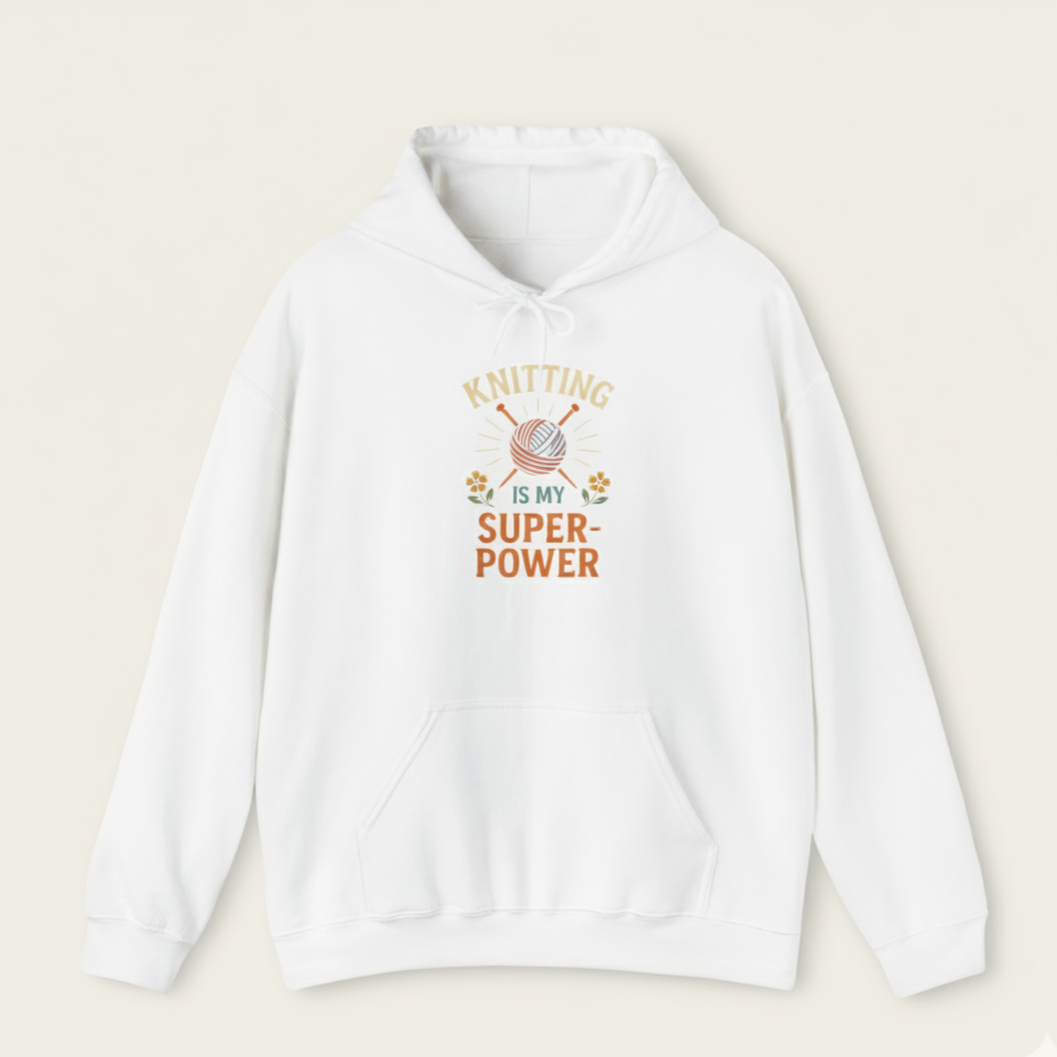 White hoodie with 'Knitting is my superpower' text and yarn graphic on a beige background